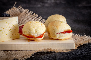 Brazilian homemade cheese bread AKA 'pao de queijo’, stuffed with guava dessert, on a rustic background.