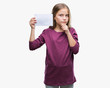 © Krakenimages.com - Young beautiful girl holding blank paper card over isolated background serious face thinking about question, very confused idea