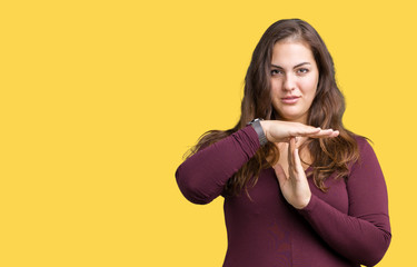 Beautiful and attractive plus size young woman wearing a dress over isolated background Doing time out gesture with hands, frustrated and serious face