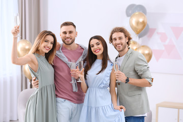 Canvas Print - Happy friends with champagne in glasses at home