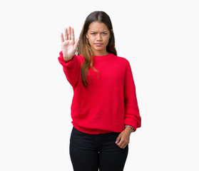 Sticker - Young beautiful brunette woman wearing red winter sweater over isolated background doing stop sing with palm of the hand. Warning expression with negative and serious gesture on the face.