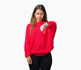 Sticker - Young beautiful brunette woman wearing red winter sweater over isolated background looking unhappy and angry showing rejection and negative with thumbs down gesture. Bad expression.