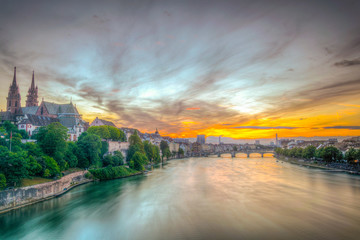 Wall Mural - Sunset view of riverside of Rhine in Basel dominated by majestic building of Munster church, Switzerland