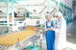 © Seventyfour - Portrait of two women working at factory  standing by conveyor belt at modern  food production, copy space