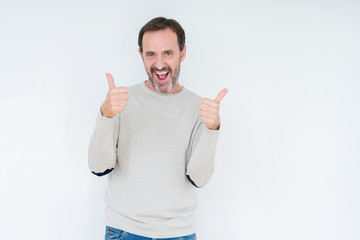 Elegant senior man over isolated background success sign doing positive gesture with hand, thumbs up smiling and happy. Looking at the camera with cheerful expression, winner gesture.