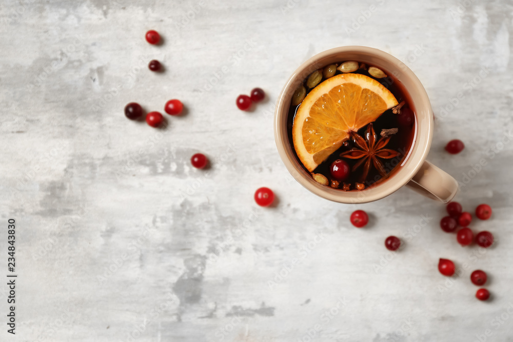 Cup of tasty mulled wine on light background