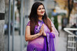 © AS Photo Family - Indian hindu girl at traditional violet saree posed at street and shows namaste tatooed hands sign.