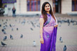© AS Photo Family - Indian hindu girl at traditional violet saree posed at street against doves.