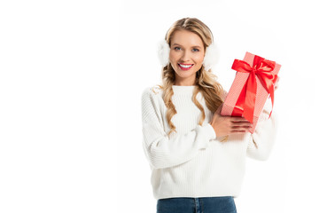 beautiful smiling girl in winter outfit holding gift box isolated on white