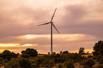 Wind power windmills and a beautiful sunset landscape. Clean and ecological energy being generated with the wind of nature through these propellers