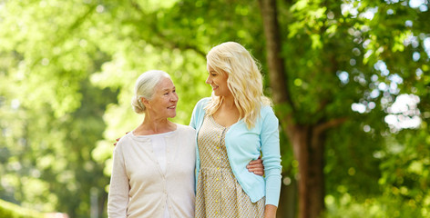 Canvas Print - family, generation and people concept - happy smiling young daughter with senior mother hugging at park