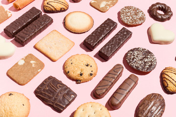 Variety of traditional cookies arranged geometrically on pink background