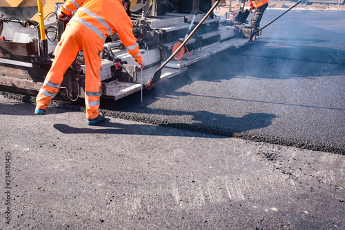 Cuadros en Lienzo Straßenbau - neue Asphaltdecke wird gezogen, Arbeiter misst die Schichtdicke