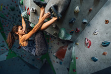 The Girl Hangs On The Ledges Climbing The Wall In Training Room