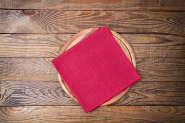 Wall Mural - Brown old vintage wooden table with framed red tablecloth napkin and pizza cutting board.Thanksgiving day and Cristmas table concept. Top view and copy space. Selective focus