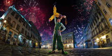 Night Street Circus Performance Whit Clown, Juggler. Festival City Background. Fireworks And Celebration Atmosphere. Wide Engle Photo