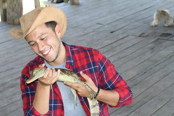 Ethnic man holding baby caiman