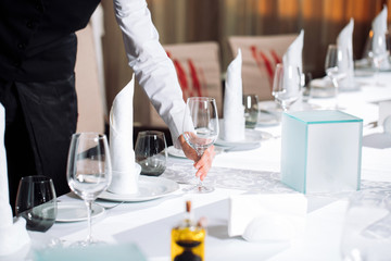 Wall Mural - Waiter serving table in the restaurant preparing to receive guests.