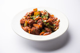 Fototapeta  - Indian Chilli Chicken dry, served in a plate over moody background. Selective focus