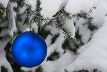 Blue Christmas Tree Ball On A Snow-covered Tree Branch