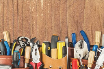 Tool belt with tools on wooden background