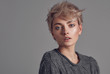 © kiuikson - Portrait of woman with blond short hair isolated on gray background