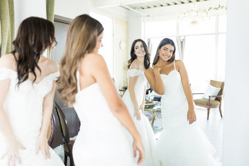 Friends Doing Try-On Of Wedding Gowns In Store