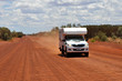 white 4x4 offroad pick up camper van approaching on red sand gravel road in the australian outback