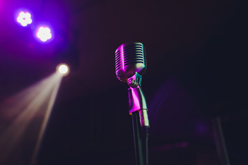 Wall Mural - Retro microphone against blur colorful light restaurant background.