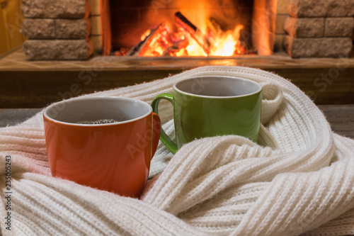 Cozy Scene Near Fireplace With Cups Of Hot Tea And Cozy Warm Scarf