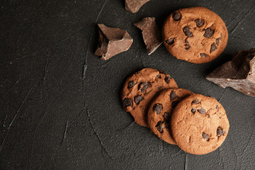 Wall Mural - Tasty chocolate chip cookies on dark background, flat lay. Space for text