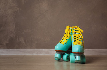 Wall Mural - vintage roller skates on floor near brown wall. space for text