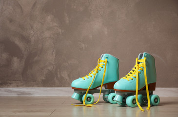 Wall Mural - vintage roller skates on floor near brown wall. space for text