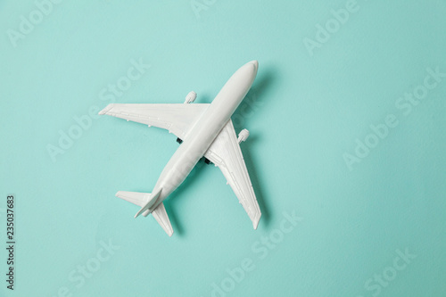Fényképezés Simply flat lay design miniature toy model plane on blue pastel colorful paper trendy background