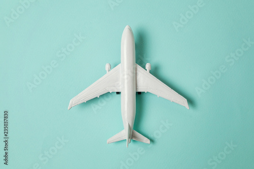 Fényképezés Simply flat lay design miniature toy model plane on blue pastel colorful paper trendy background