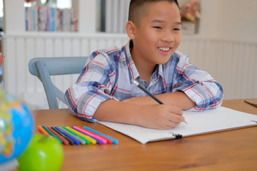 Wall Mural - asian kid boy child schoolboy drawing picture. children activity at home