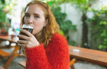 Woman Having A Glass Of Beer In Outdoor Cafe