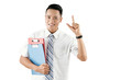 © DragonImages - Portrait of young attractive Asian male office worker holding folders with papers, showing forefinger up and smiling at camera happily