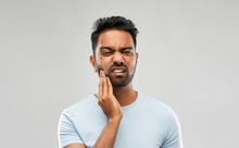 People, Dentistry And Health Problem Concept - Indian Man Suffering From Toothache Over Grey Background