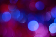 Bokeh. Holiday Background. Christmas Lights. Glitter. Defocused Sparkles. New Year Backdrop. Festive Wallpaper. Blinks. Carnival. Bokeh Retro Style Photo. Violet. Red. Blue.