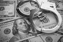 Pair Of Metal Police Handcuffs On USD US Dollar Banknotes Money Cash Background.  Corruption, Dirty Money, Gambling Or Financial Crime Ideas Concept.