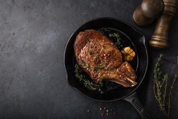 Canvas Print - beef steak on cast iron pan, dark background