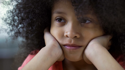 Lonely sad black girl looking straight, thinking about friends, face closeup