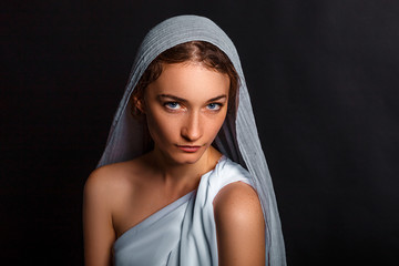 beautiful young woman with a scarf on her head, and a rosary in her hands, humble look, believing woman