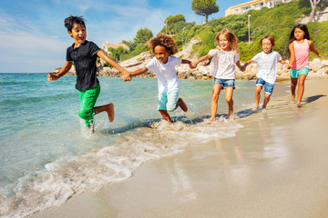 Wall Mural - Friends running one after another on the beach