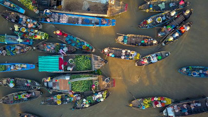 aerial: local people buying and selling colorful produce from wooden boats.