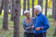 © pucko_ns - Older couple jogging in the park with distance tracker watch on hands  and smile