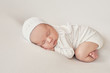 © Aleksandr - Cute newborn baby girl lies swaddled in a white blanket. Baby goods packaging template. Closeup portrait of newborn baby with smile on face. Healthy and medical concept.