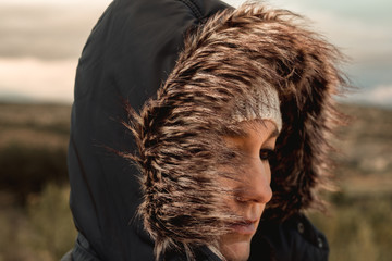 A young woman with a hood in the field