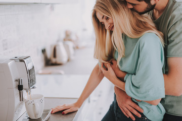 Stylish couple brewing aromatic coffee and enjoying in each other arms